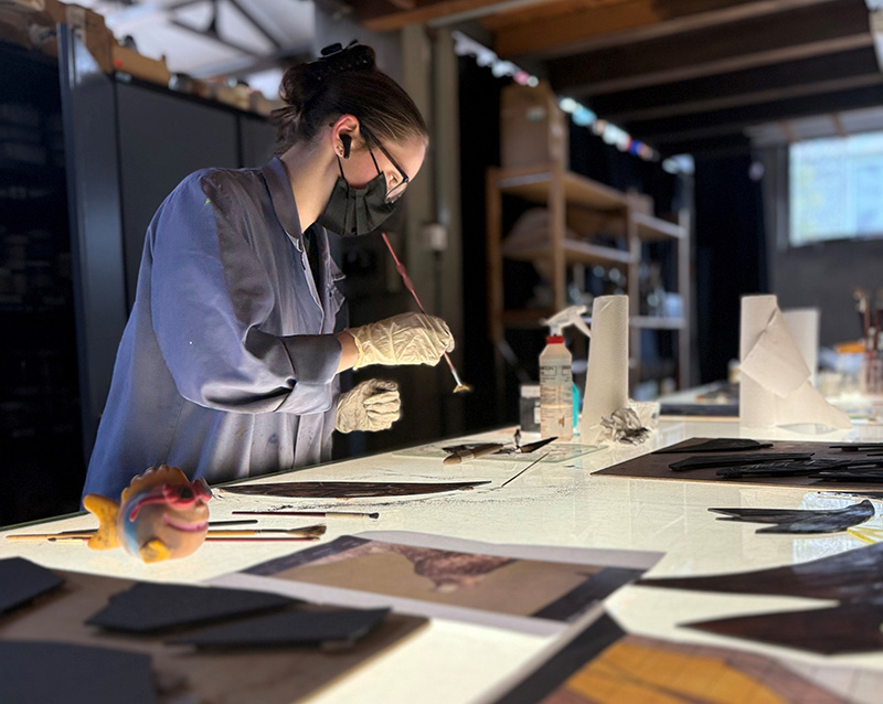 Photographie d'une peintre verrière au travail