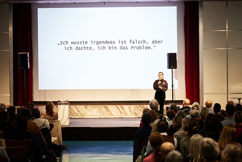 Photographie d'une conférence avec projection sur grand écran pour le forum « Stand by you »